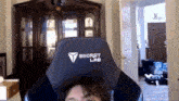 a person is sitting in a secret lab gaming chair in a room .