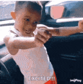 a little boy is sitting in a car with his arms outstretched and the words excited written below him .