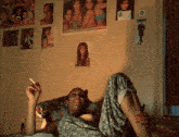 a woman laying on a bed smoking a cigarette with a poster on the wall that says revlon on it