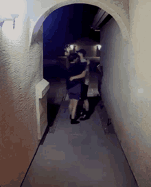 a man and woman are hugging in a hallway