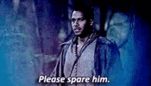 a man is standing in front of a wall and saying please spare him