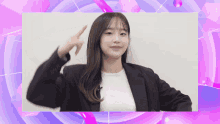 a woman in a black jacket and white shirt is giving a peace sign