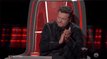 a man sitting in a chair with the word nbc on the bottom of it