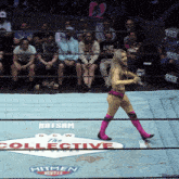 a woman in a bikini is walking in a wrestling ring with a sign that says the collective