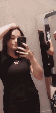 a woman taking a selfie in front of a mirror