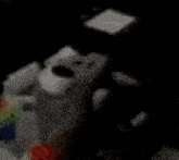 a stuffed animal is sitting on a table next to a cell phone .