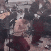 a man without a shirt is kneeling down on a stage while playing a guitar and singing into a microphone .