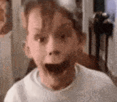 a close up of a child 's face with a surprised look on it .