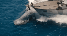 a boat in the ocean with a person jumping off of it
