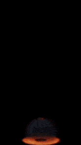 a piece of meat is floating in the air above a pile of fire