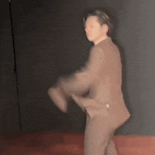 a blurry picture of a man in a suit dancing on a wooden floor .