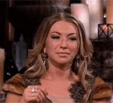 a woman is holding a glass of wine and making a face .