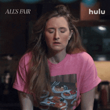 a woman wearing a pink t-shirt with a picture of pancakes on it