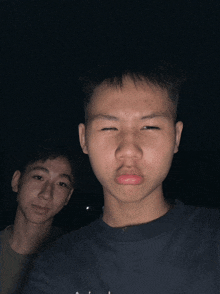 two young men are posing for a picture and one is wearing a shirt that says ' tommy hilfiger ' on it