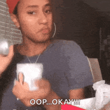 a woman is holding a cup and says okay