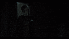 a yellow teddy bear in a dark room with the number 8 on its chest