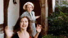 two women are standing in front of a door that has the number 17 on it