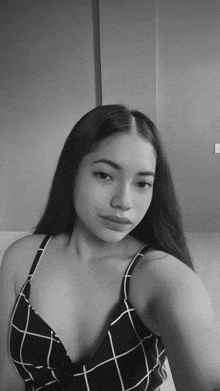 a woman in a black and white photo is wearing a plaid top