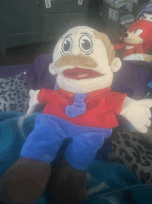 a stuffed toy with a mustache and tie is laying on a bed