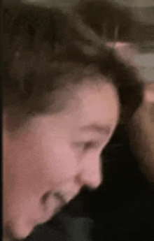 a close up of a person 's face with a shaved head and a surprised look on their face .