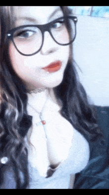 a woman wearing glasses and a choker necklace takes a selfie