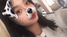 a woman wearing a dalmatian dog mask on her face