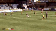a group of soccer players on a field with a score of 0-0