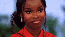 a close up of a woman 's face with a red shirt on