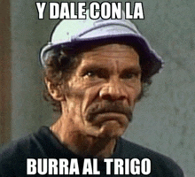 a man with a hat on says y dale con la burra al trigo on his face