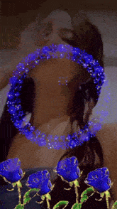 a woman 's face is surrounded by blue roses