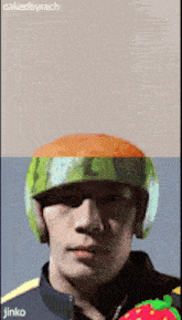 a man is wearing a watermelon helmet and the name jinko is on the bottom right