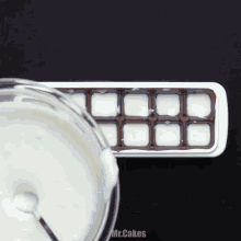 a bowl of milk is being poured into an ice cube tray with the words mr.cakes below it