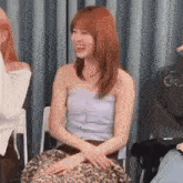 a woman is sitting in a chair with a leopard print skirt and laughing .