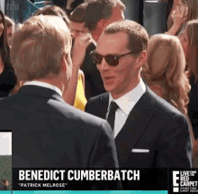 benedict cumberbatch is wearing sunglasses while talking to another man