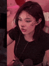 a girl with leopard print on her face is wearing headphones and a black shirt
