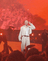 a man singing into a microphone in front of a large crowd
