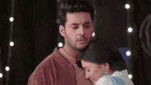 a man is hugging a woman in a dark room .