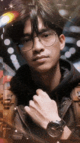 a man wearing glasses and a watch is looking at the camera
