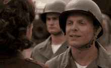 a man in a helmet talks to another man