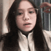 a close up of a woman wearing glasses and a jacket