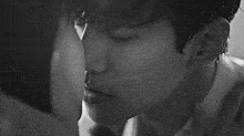 a close up of a man 's face with a woman 's face in the background .