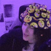 a girl wearing a hat with smiley faces on it