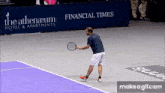 a man is playing tennis in front of a banner for the athenaeum hotel and apartments