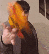 a man in a grey jacket is holding a yellow and red object