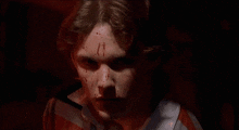 a man with blood on his face is wearing a red and white striped shirt