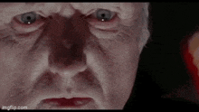 a close up of a man 's face with a very angry expression on his face .