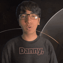 a man wearing glasses and a shirt that says danny on it