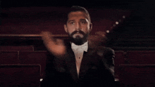 a man in a tuxedo is sitting in an auditorium