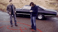 two men are standing in front of a car with a red circle around them