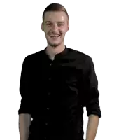 a man in a black shirt is smiling with his hand on his waist